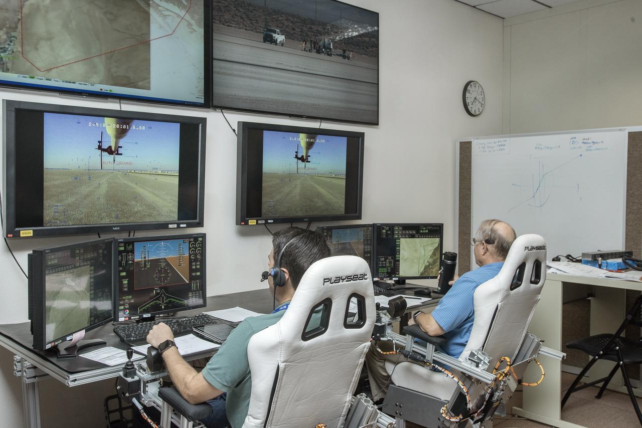 Scott Howe, X-56A chief pilot, and Dana Purifoy, co-pilot, complete preflight checks from a ground cockpit in the control room.