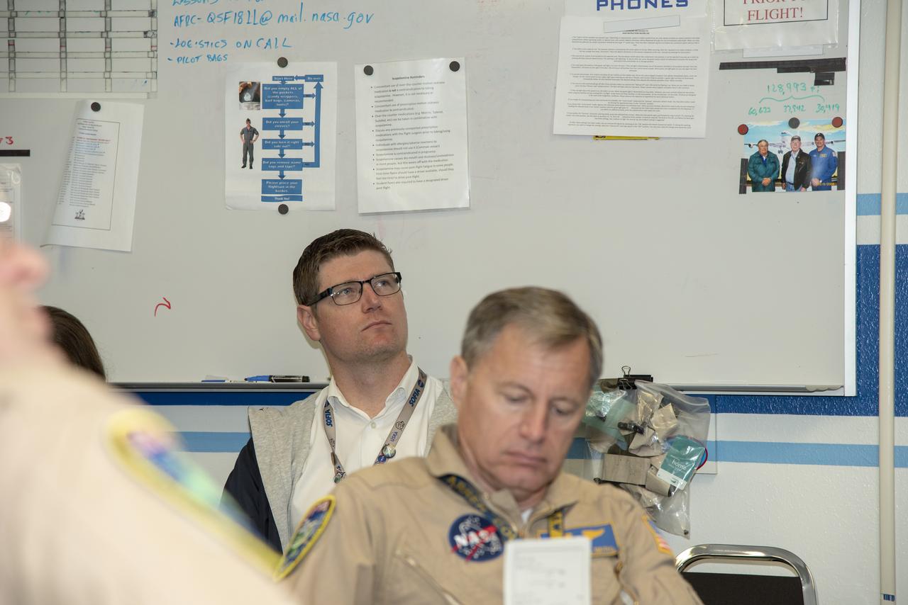 The flight operations crew for NASA's QSF18 flight series debriefs following a flight with the F/A-18 research aircraft. The flight included a quiet supersonic dive maneuver at high altitudes off the coast to produce a sonic boom out over the ocean, with the intention of producing quieter "thumps" on land.
