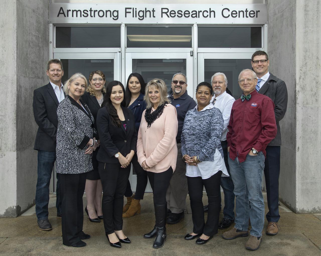 Armstrong Flight Research Center Office of Strategic Communication group photo in front of the Center's building 4800. Back row (left to right) Kevin Rohrer, Kate Squires, Jessica Arreola, Jay Levine, Steve Lighthill and Matt Kamlet. Bottom row (left to right) Leslie Williams, Elvia Valenzuela, Mary Anne Harness, Kim Lewis-Bias and Christian Gelzer.