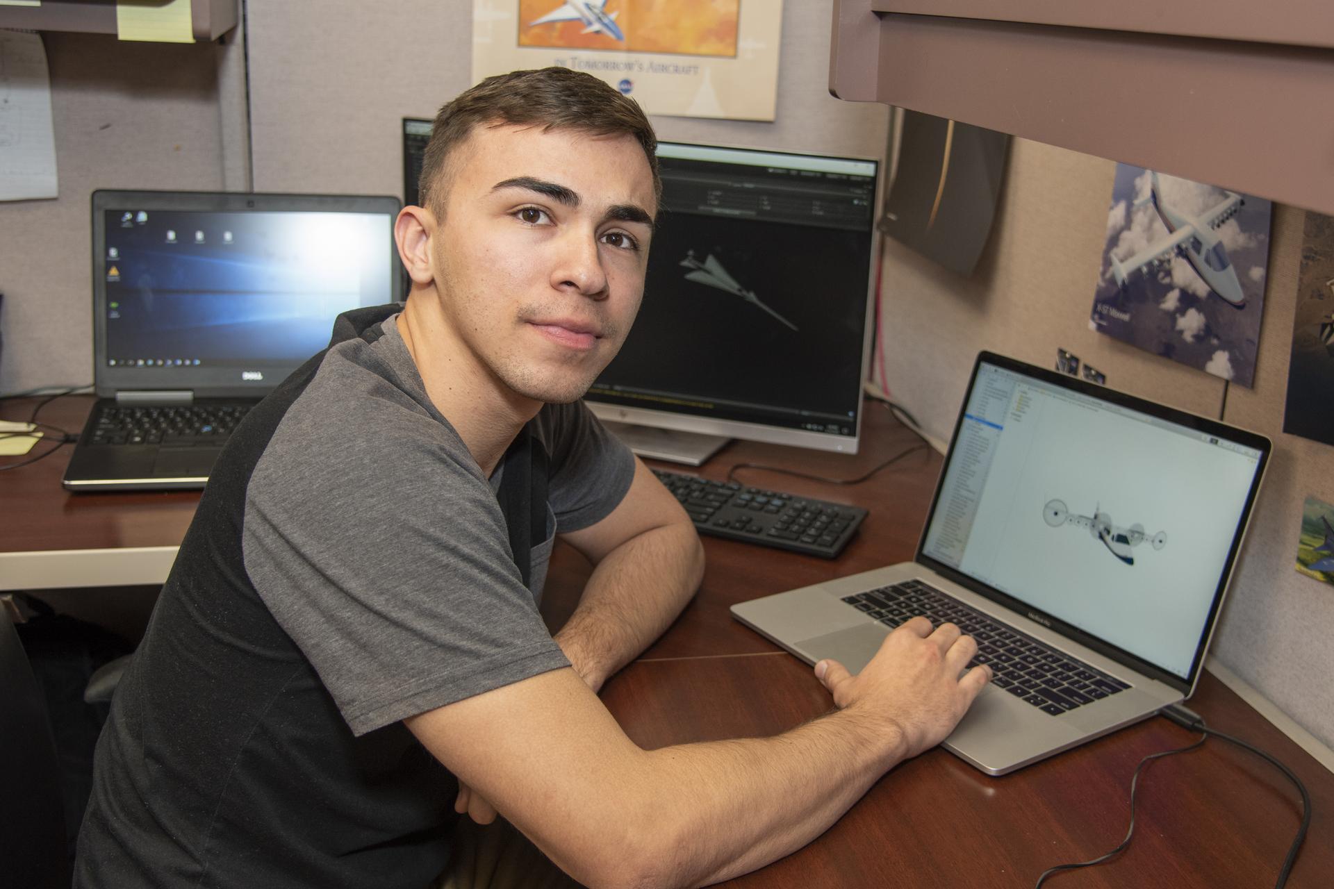 An intern sits at his computer.