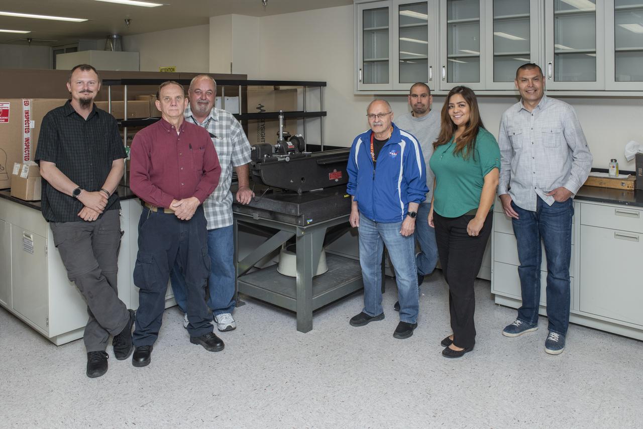 NASA’s Armstrong Flight Research Center Calibration Laboratory in California has a workload that is 80 percent related to items used in preparing aircraft for flight. To successfully complete that work takes a staff, which from left includes Paul Craig, James Kelly, David Swindle, Arnold Gonzales, Ronnie Juvinall, Anita Solorio and Alex Rivera. They are standing by a 1948 calibration tool they call the boat anchor, which still is a valued asset. 