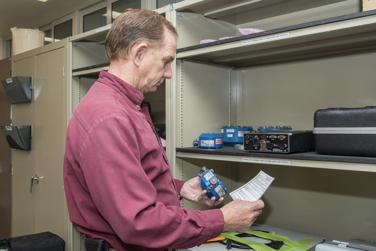 James Kelly, who is responsible for pickup and delivery of items to and from NASA Armstrong's Calibration Laboratory, checks the numbers of a part before he puts it on the delivery vehicle for transport back to a customer.