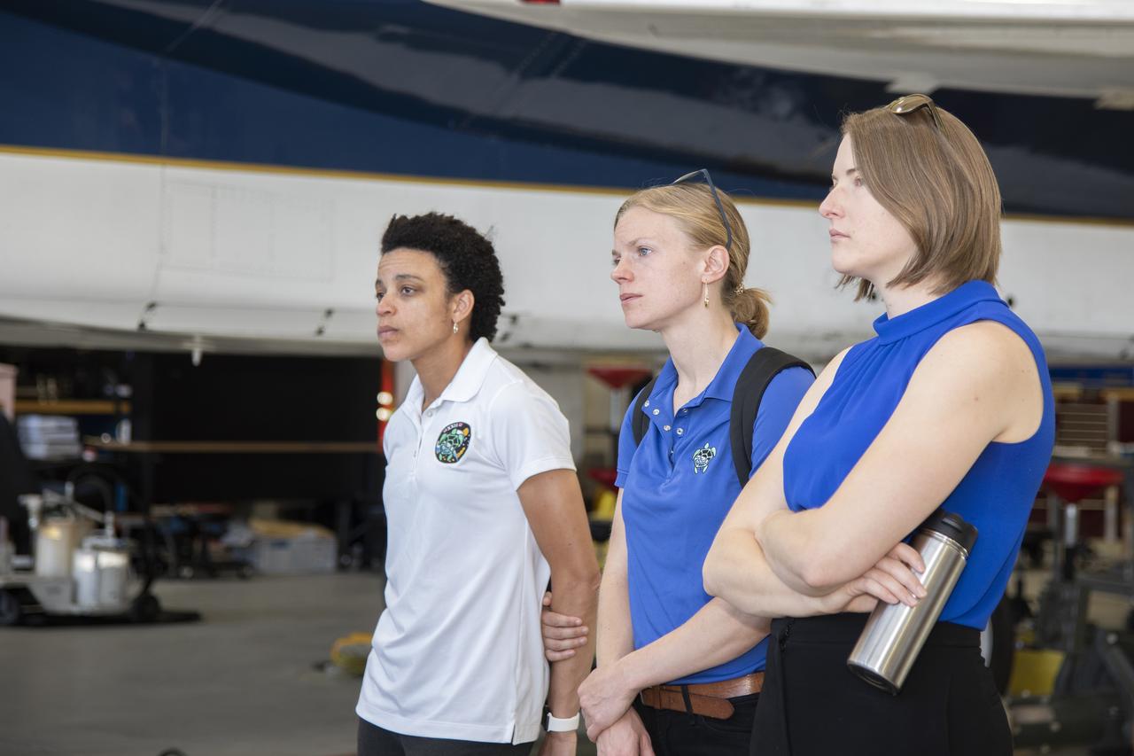NASA’s 2017 astronaut candidates (L to R) Jessica Watkins, Zena Cardman, Kayla Barron toured aircraft hangar at Armstrong Flight Research Center, in Southern California where they were briefed on the use of Armstrong's F-15 and F-18 aircraft for studying sonic booms.  The aircraft will be used during the development of the low-boom X-59 aircraft that is planned to fly supersonically over land, which is not allowed at this time because of the loud noise created when flying beyond the speed of sound.