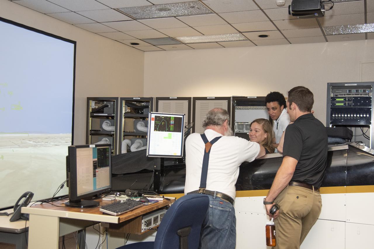 NASA's 2017 astronaut candidates (L to R) Jenni Sidey-Gibbons, Jessica Watkins and Joshua Kutryk practice flying in an F-18 aircraft cockpit simulator at Armstrong Flight Research Center, in Southern California. The F-18's are flown for research support and pilot proficiency. Currently, the F-18 is conducting supersonic research in support of the X-59 QueSST overall mission.