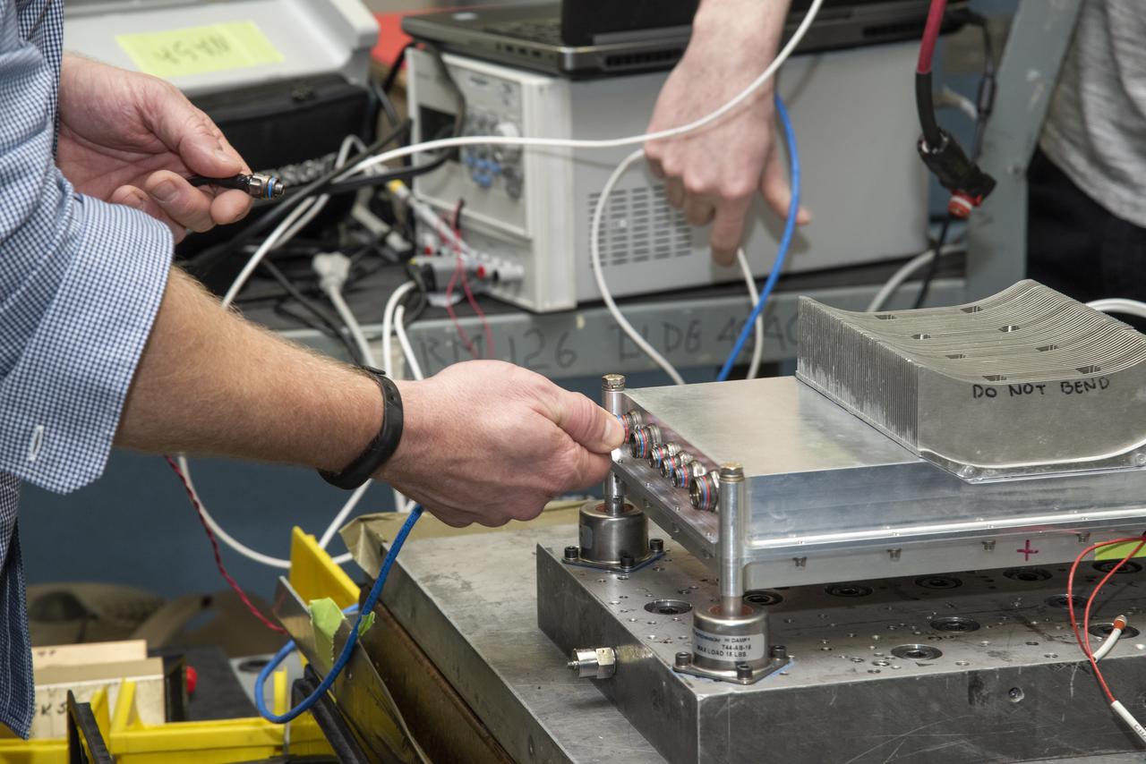Engineers from NASA's Armstrong Flight Research Center and Empirical Systems Aerospace prepare a cruise motor controller, planned to be used on NASA's all-electric X-57 Maxwell, for vibration testing at Armstrong's environmental lab. Testing the cruise motor controller at various vibration levels, based on baseline flight testing in the project's first phase, helps ensure that the hardware will withstand similar vibration in flight conditions. X-57, NASA's first all-electric experimental aircraft, or X-plane, will fly in its first all-electric configuration in 2020.