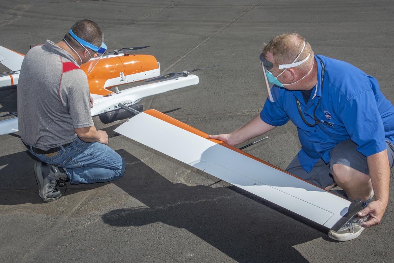 Derek Abramson and Robert Jensen install a wing on the Hybrid Quadrotor 90C (HQ-90) at NASA Armstrong Flight Research Center's Dale Reed Subscale Flight Research Lab in California on Oct. 1, 2020. This vertical lift and transition remotely piloted aircraft arrived in pieces packed in crates for the Resilient Autonomy project to test software in flight.