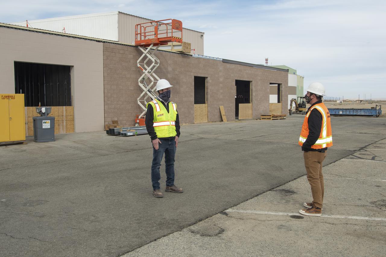 Collin Morris, CJW/MZT project manager and Bryan Watters, NASA civil/structural engineer and project manager, discuss work on the east side of Building 4826. Building 4826 is the future home of the X-59 Quiet SuperSonic Technology aircraft, where a conference room, offices, restrooms and a communications room will be added at NASA's Armstrong Flight Research Center in Edwards, California.