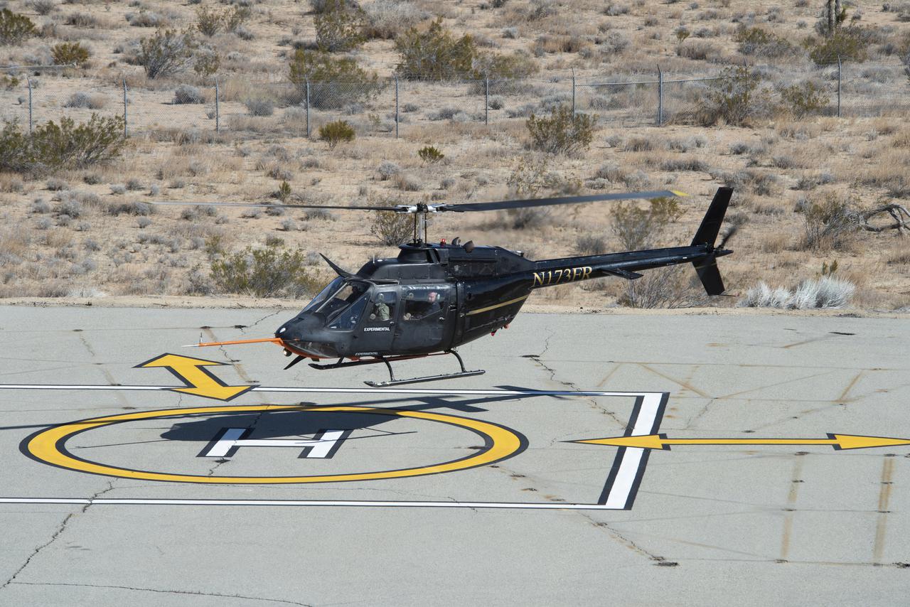 Flight Research Inc.’s Bell OH-58C Kiowa helicopter hovers over a helipad after completing an urban air mobility approach at NASA’s Armstrong Flight Research Center in California in March 2021. The Advanced Air Mobility National Campaign studied the viability of various urban air mobility approach options during a second phase called build II. This helicopter was used as a surrogate urban air mobility or air taxi vehicle.