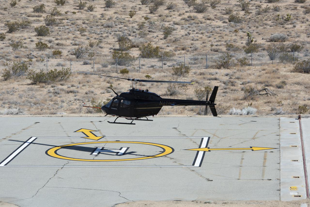 Flight Research Inc.’s Bell OH-58C Kiowa helicopter takes off from a research helipad at NASA’s Armstrong Flight Research Center in California in March 2021. The Advanced Air Mobility National Campaign project utilized several heliports and vertiports to study airspace management evolutions that could enable future urban air mobility operations. Tests were conducted during build II where this helicopter was used as a surrogate urban air mobility or air taxi vehicle.