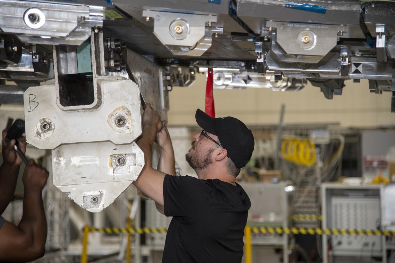 The outboard pylon load fixture is secured for the F/A-18E from the Naval Air Systems Command (NAVAIR) in Patuxent River, Maryland. The aircraft is in NASA’s Armstrong Flight Research Center Flight Loads Laboratory in Edwards, California, for the center’s biggest load calibrations tests. This testing is needed before the aircraft can serve as a test vehicle for determining if it can safely manage maneuvers and proposed upgrades. 
