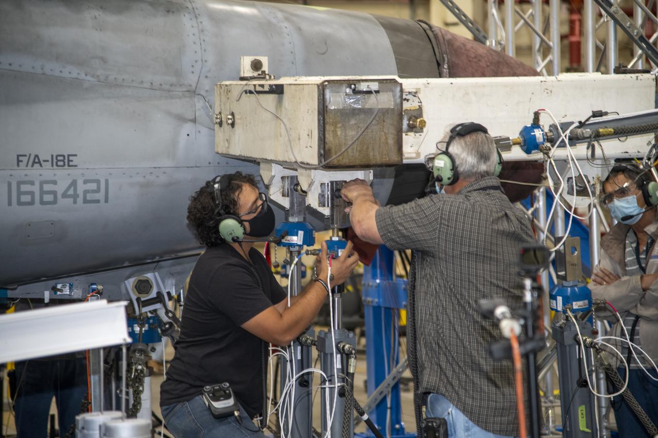 The actuator on the F/A-18E from the Naval Air Systems Command (NAVAIR) in Patuxent River, Maryland, is pinned to the horizontal tail load test fixture. The aircraft is in NASAâ€™s Armstrong Flight Research Center Flight Loads Laboratory in Edwards, California, for the centerâ€™s biggest load calibrations tests. This testing is needed before the aircraft can serve as a test vehicle for determining if it can safely manage maneuvers and proposed upgrades. 