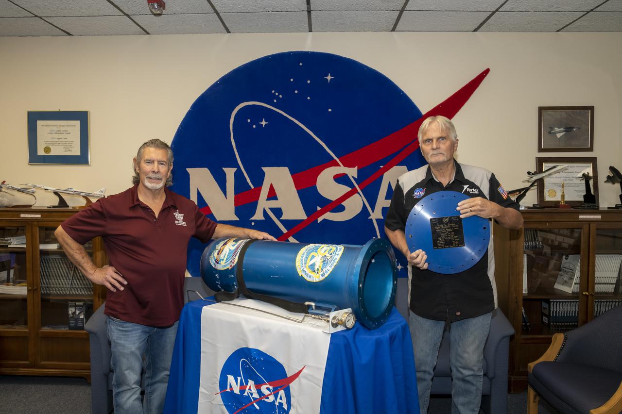 Andy Blua and Don Whitfield stand by the time capsule they helped construct 25 years ago on NASA Armstrong Flight Research Center's 50th anniversary. It was recently opened at the center, located in Edwards, California, on Oct. 13, 2021. The time capsule was opened as part of the activities commemorating the center's 75th anniversary.