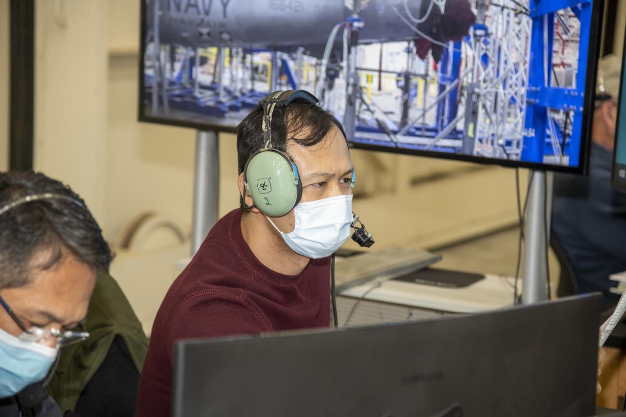 Larry Hudson and Tony Chen inspect test data during horizontal tail testing on a F/A-18E from the Naval Air Systems Command (NAVAIR) in Patuxent River, Maryland. The aircraft is in NASA's Armstrong Flight Research Center Flight Loads Laboratory in Edwards, California, for the center's biggest load calibrations tests. This testing is needed before the aircraft can serve as a test vehicle for determining if it can safely manage maneuvers and proposed upgrades.