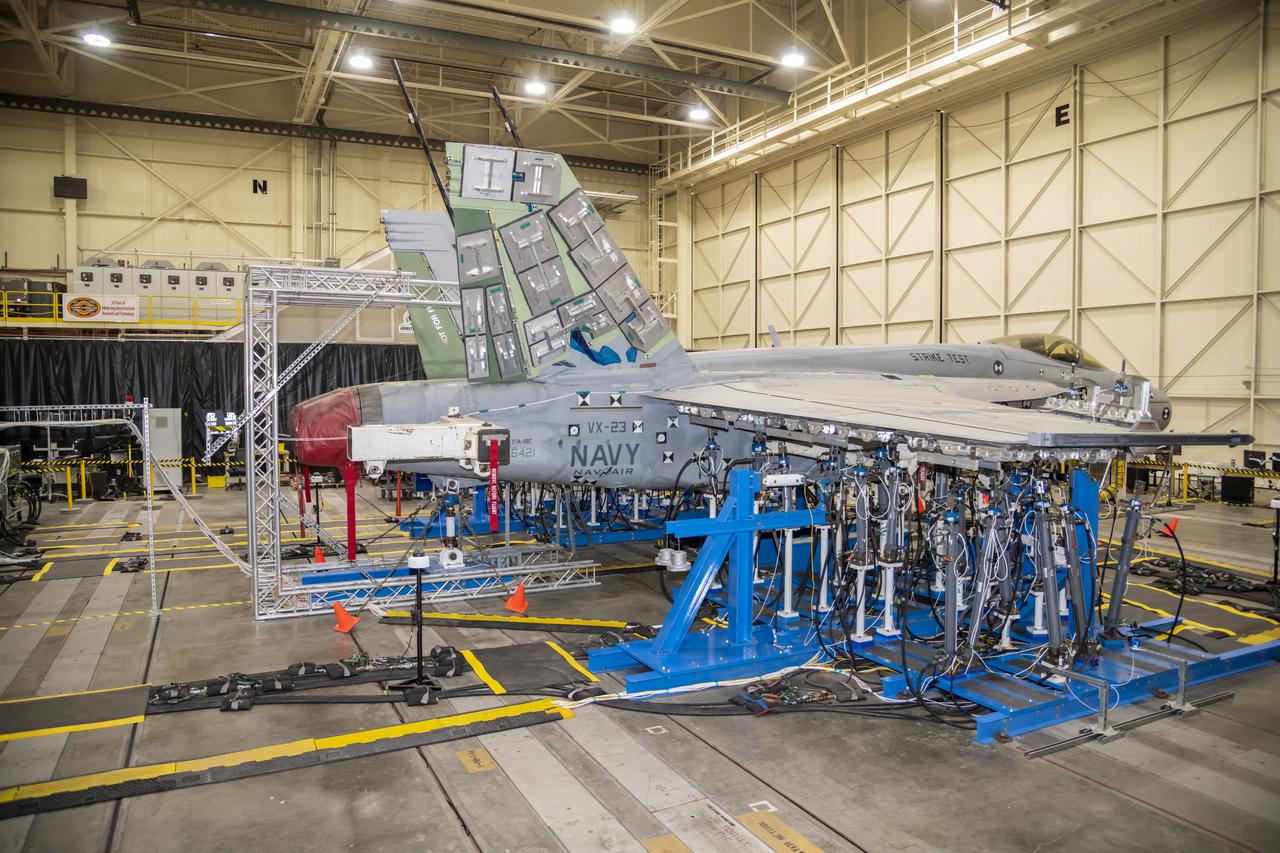 Wing load test hardware is setup under wing of a F/A-18E from the Naval Air Systems Command (NAVAIR) in Patuxent River, Maryland. The aircraft is in NASAâ€™s Armstrong Flight Research Center Flight Loads Laboratory in Edwards, California, for the centerâ€™s biggest load calibrations tests. This testing is needed before the aircraft can serve as a test vehicle for determining if it can safely manage maneuvers and proposed upgrades. 