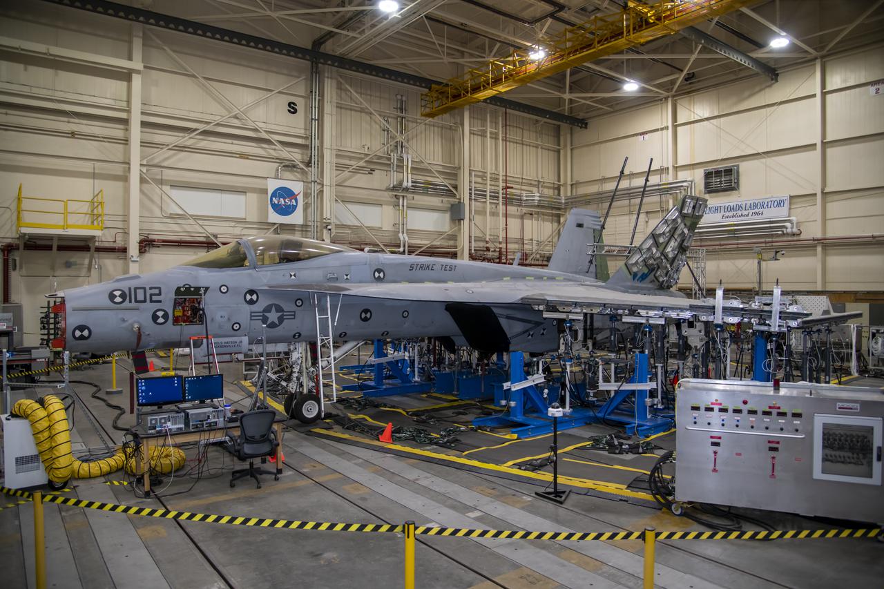 This view shows the left wing loading test configuration and testing area of an F/A-18E from the Naval Air Systems Command (NAVAIR) in Patuxent River, Maryland. The aircraft is in NASA's Armstrong Flight Research Center Flight Loads Laboratory in Edwards, California, for the center's biggest load calibrations tests. This testing is needed before the aircraft can serve as a test vehicle for determining if it can safely manage maneuvers and proposed upgrades.