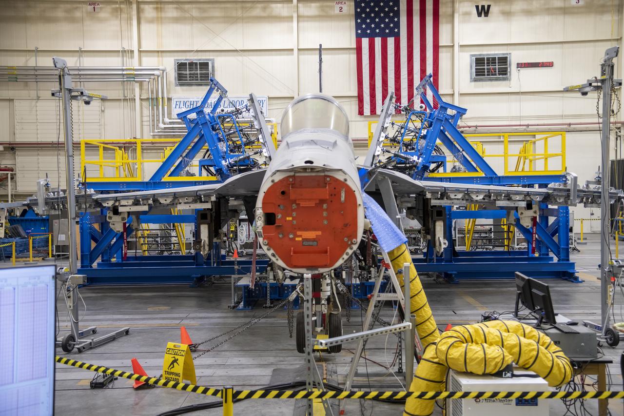 This is a front view of the vertical tail loads testing on a Navy F/A-18E that concluded in May, wrapping up the third phase of research at NASA’s Armstrong Flight Research Center in Edwards, California. The first two phases included loads calibration testing focused on the aircraft’s horizontal tails and wings. The aircraft is from the Naval Air Systems Command (NAVAIR) in Patuxent River, Maryland. NAVAIR retired its previous loads test aircraft and NASA Armstrong staff are assisting to prepare the new aircraft for its role to help safely manage flight maneuvers and determine how the F/A-18E fleet will perform if proposed upgrades are incorporated.