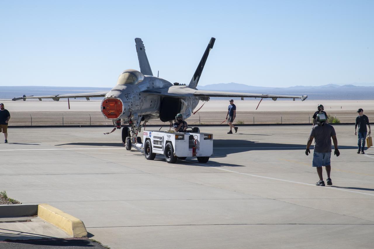 An F/A-18E from the Naval Air Systems Command (NAVAIR) in Patuxent River, Maryland, is moved from NASAâ€™s Armstrong Flight Research Center Flight Loads Laboratory in Edwards, California, to a hangar where it will undergo final preparations to return to its squadron. The aircraft underwent the centerâ€™s biggest load calibrations tests. The testing will permit the aircraft to serve as a test vehicle to determine if it can safely manage maneuvers and proposed upgrades.