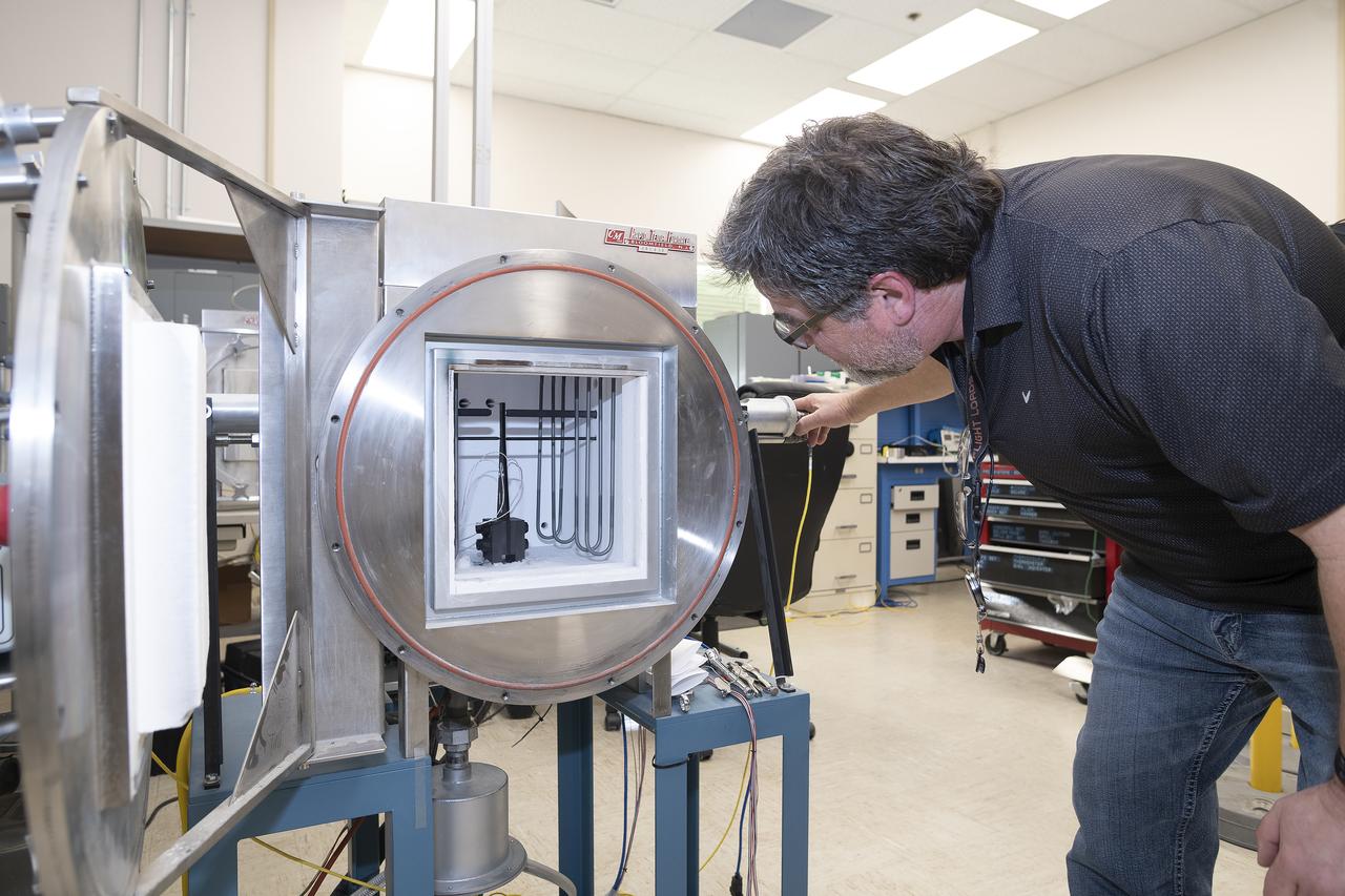 Anthony piazza, a researcher at NASA’s Armstrong Flight Research center in Edwards, California, works with high-temperature strain sensors. This test article is a bending load bar, which enables high-temperature optical strain sensor research up to 1,800 degrees Fahrenheit.