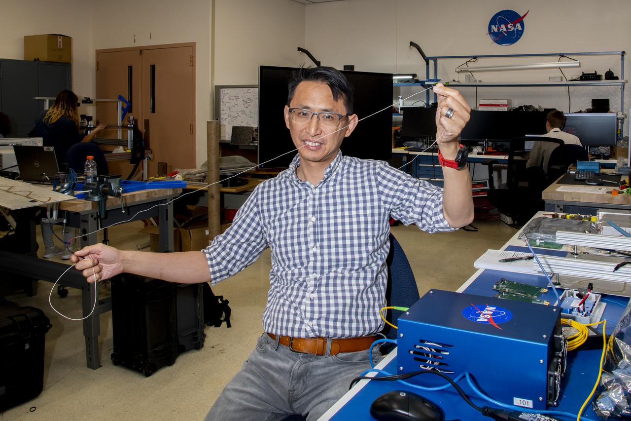 Patrick Chan, electronics engineer, and NASA Armstrong Flight Research Center’s FOSS portfolio project manager, shows a fiber used in a temperature sensing system. Armstrong’s Fiber Optic Sensing System was used to measure temperatures during tests aimed at turning oxygen into liquid oxygen. Testing was conducted at NASA’s Glenn Research Center in Cleveland, Ohio.