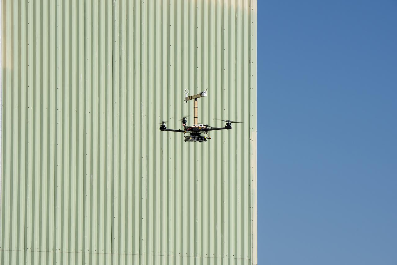 The Alta-X aircraft flies by the former space shuttle hangar at NASA’s Armstrong Flight Research Center in Edwards, California, as part of the Advanced Exploration of Reliable Operation at Low Altitudes: Meteorology, Simulation and Technology campaign. The campaign was at NASA Armstrong Flight to study wind from the ground to 2,000 feet to provide data to assist future drones to safely land on rooftop hubs called vertiports and to potentially improve weather prediction.