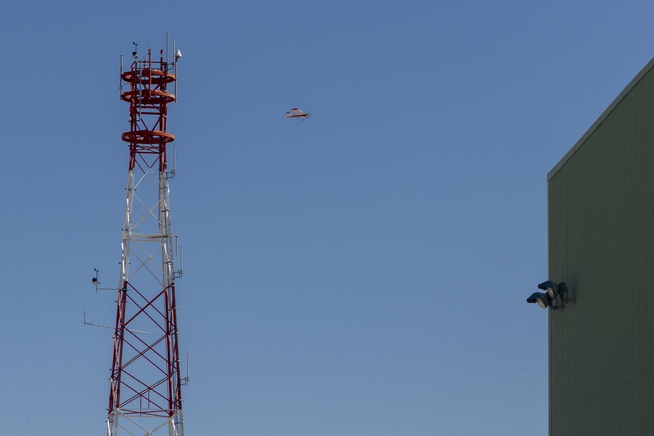 The DROID 2 (Dryden Remotely Operated Integrated Drone 2) flies by a 140-foot instrumented tower and the former space shuttle hangar at NASA's Armstrong Flight Research Center in Edwards, California, as part of the Advanced Exploration of Reliable Operation at Low Altitudes: Meteorology, Simulation, and Technology campaign. The focus was to study wind to provide data for safe takeoff and landing of future air taxis.