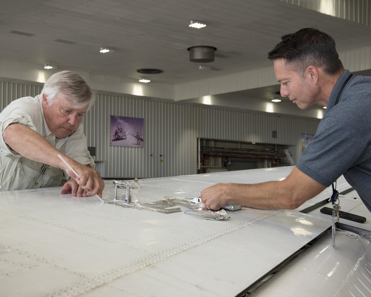 Cal Poly San Luis Obispo Professor Russ Westphal, left, and NASA Armstrong’s Technology Transfer Officer Benjamin Tomlinson remove the Boundary Layer Data System (BLDS) sensor attached to the wing of a Beechcraft Beech 200 Super King Air. The BLDS was flight tested at NASA’s Armstrong Flight Research Center to showcase rapid and flexible flight-testing capabilities.