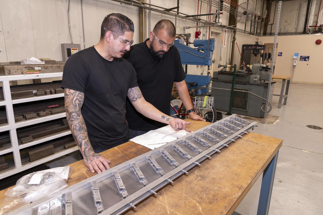 Matthew Sanchez, left, consults with Sal Navarro on assembling wing ribs to the 10-foot model of the Transonic Truss-Braced Wing at NASA’s Armstrong Flight Research Center, in Edwards, California. The aircraft concept involves a wing braced on an aircraft using diagonal struts that also add lift and could result in significantly improved aerodynamics.