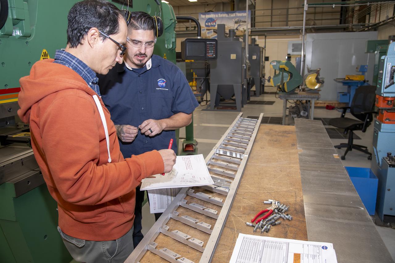 Matthew Sanchez consults with Andrew Holguin on the strut for a 10-foot model of the Transonic Truss-Braced Wing at NASA’s Armstrong Flight Research Center, in Edwards, California. The aircraft concept involves a wing braced on an aircraft using diagonal struts that also add lift and could result in significantly improved aerodynamics.