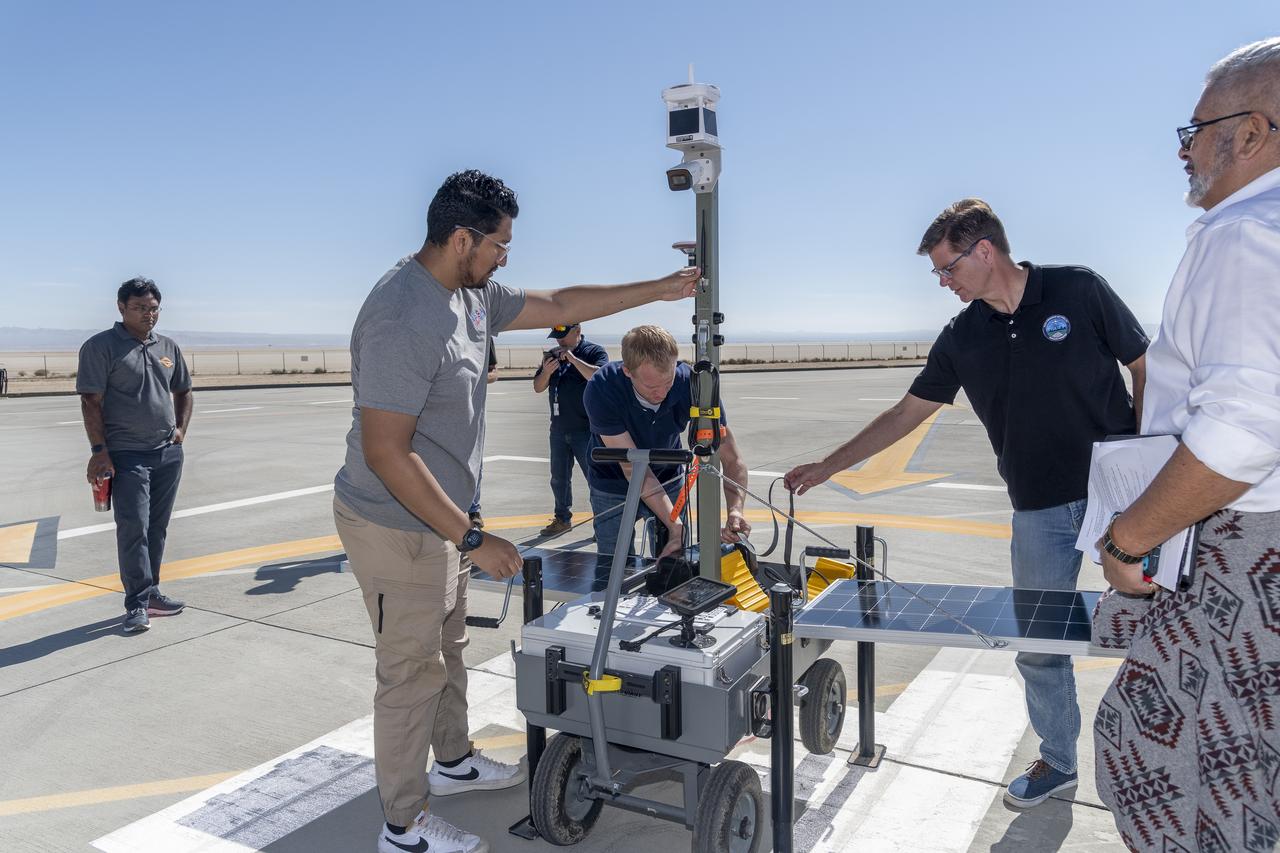 NASA operations engineer Daniel Velasquez, left, is reviewing the Mobile Vertipad Sensor Package system as part of the Air Mobility Pathways test project at NASA's Armstrong Flight Research Center in Edwards, California on October 17, 2023. The portable system allows Advanced Air Mobility researchers to test and evaluate several factors involved in monitoring takeoff and landing conditions at vertipad sites. "Vertipads" or "vertiports" will be where future air taxis will land and take off to transport passengers.