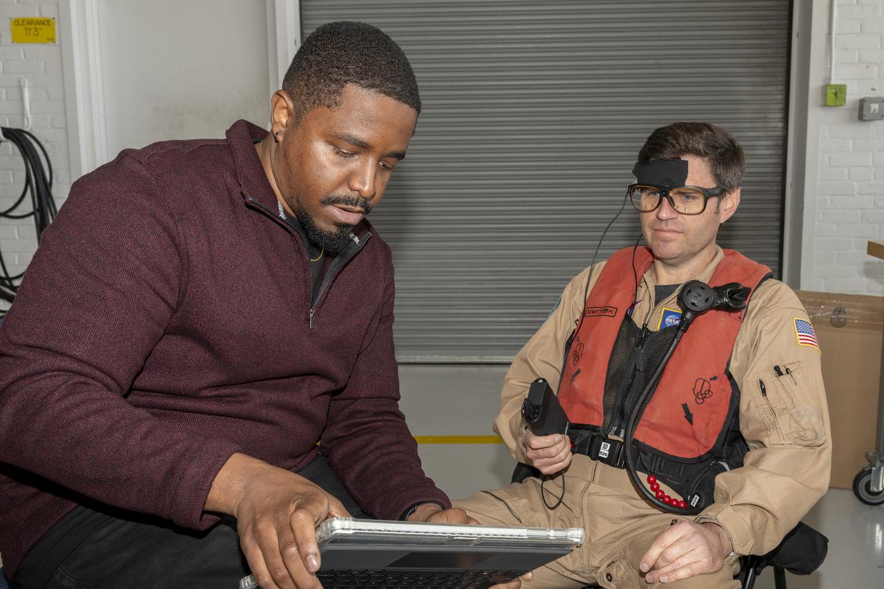 NASA human factors researcher Kevin J. Monk, left, and NASA pilot Scott Howe verify the connectivity and accuracy of the biometric sensors placed on Howe for test flight at Sikorsky Memorial Airport, Bridgeport, Connecticut on Tuesday, Oct. 24, 2023. These sensors will track various physiological responses sending the data to Monk’s computer as Howe engages with the autonomous flight software used to fly the aircraft. 