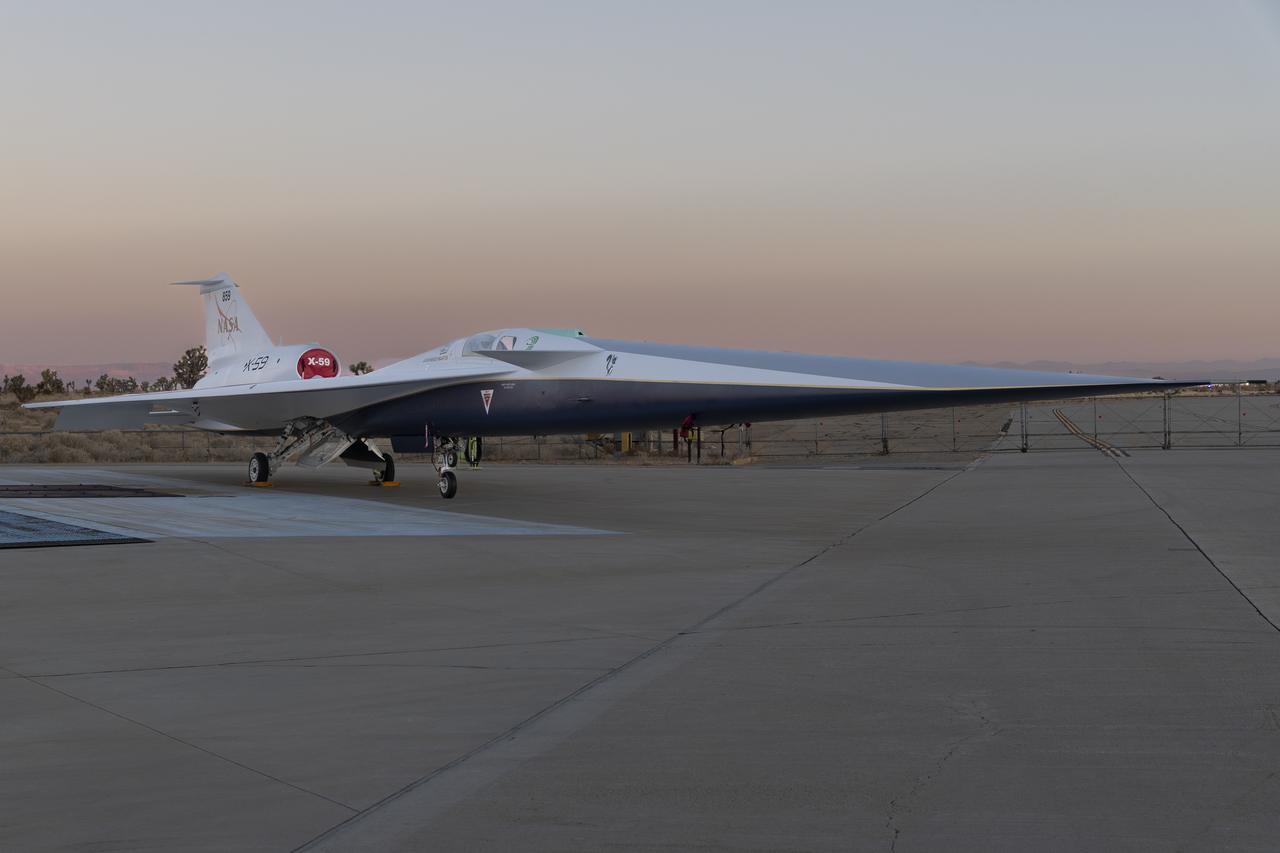 NASA’s X-59 quiet supersonic research aircraft sits on the ramp at Lockheed Martin Skunk Works in Palmdale, California during sunrise, shortly after completion of painting. With its unique design, including a 38-foot-long nose, the X-59 was built to demonstrate the ability to fly supersonic, or faster than the speed of sound, while reducing the typically loud sonic boom produced by aircraft at such speeds to a quieter sonic “thump”. The X-59 is the centerpiece of NASA’s Quesst mission, which seeks to solve one of the major barriers to supersonic flight over land, currently banned in the United States, by making sonic booms quieter. 