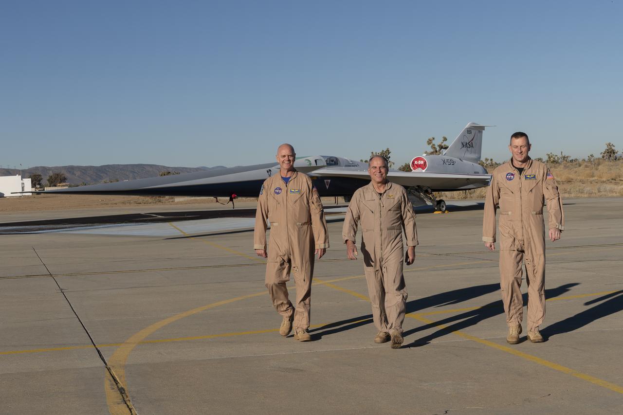 NASA test pilots Nils Larson (left) and Jim “Clue” Less (right), and Lockheed Martin test pilot Dan “Dog” Canin pose with the newly-painted X-59 as it sits on the ramp at Lockheed Martin Skunk Works in Palmdale, California. The X-59 is the centerpiece of NASA’s Quesst mission, which seeks to solve one of the major barriers to supersonic flight over land, currently banned in the United States, by making sonic booms quieter.