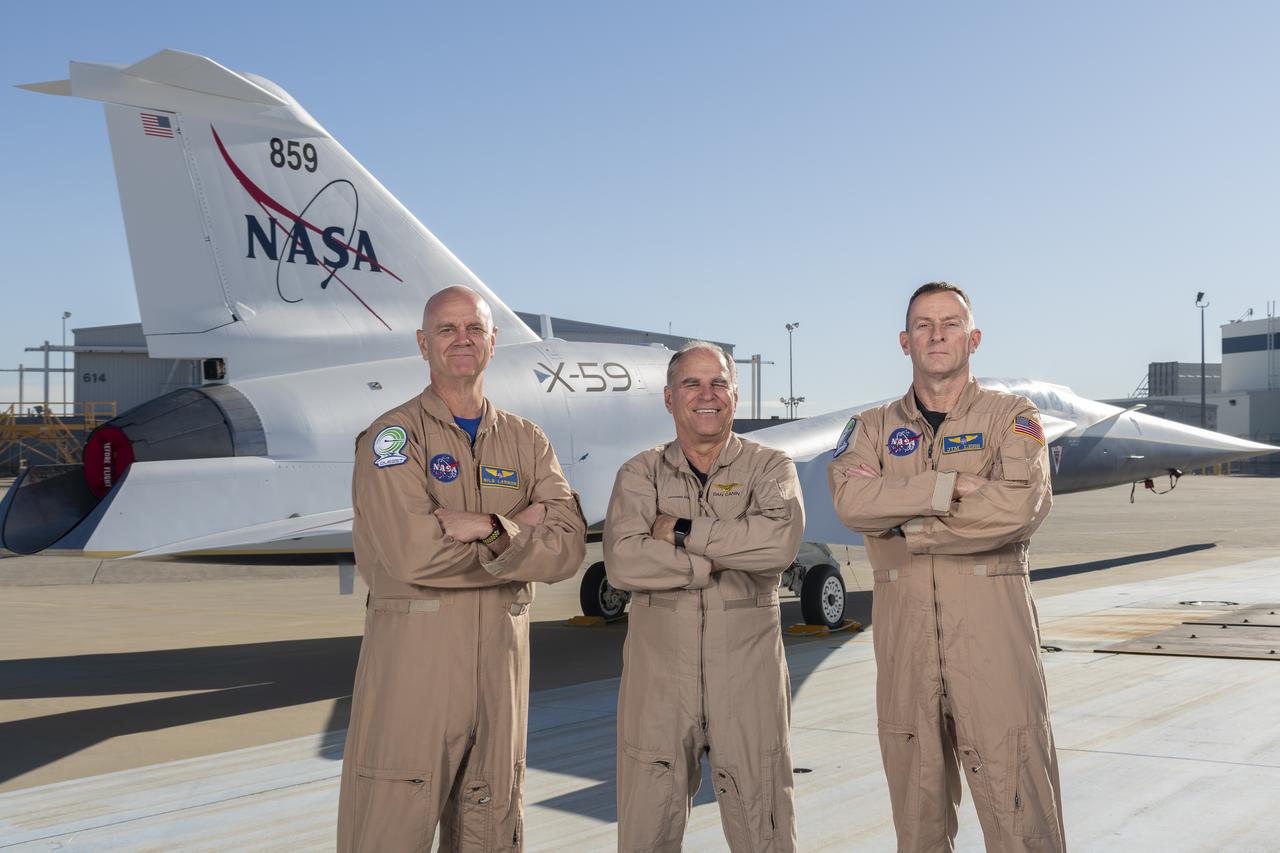 NASA test pilots Nils Larson (left) and Jim “Clue” Less (right), and Lockheed Martin test pilot Dan “Dog” Canin pose with the newly-painted X-59 as it sits on the ramp at Lockheed Martin Skunk Works in Palmdale, California. The X-59 is the centerpiece of NASA’s Quesst mission, which seeks to solve one of the major barriers to supersonic flight over land, currently banned in the United States, by making sonic booms quieter.