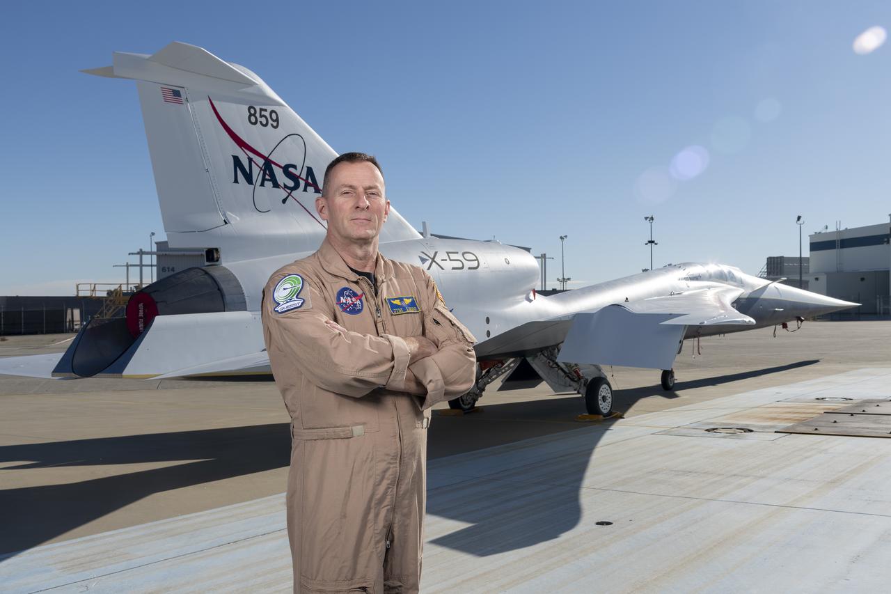 NASA test pilot Jim “Clue” Less poses with the newly-painted X-59 as it sits on the ramp at Lockheed Martin Skunk Works in Palmdale, California. The X-59 is the centerpiece of NASA’s Quesst mission, which seeks to solve one of the major barriers to supersonic flight over land, currently banned in the United States, by making sonic booms quieter.
