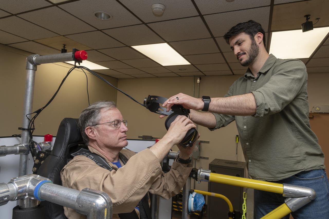 NASA test pilot Wayne Ringelberg and NASA researcher Kyle Barnes prepare for Ringelberg’s ride in the air taxi virtual reality flight simulator during a test at NASA’s Armstrong Flight Research Center in Edwards, California in March 2024.