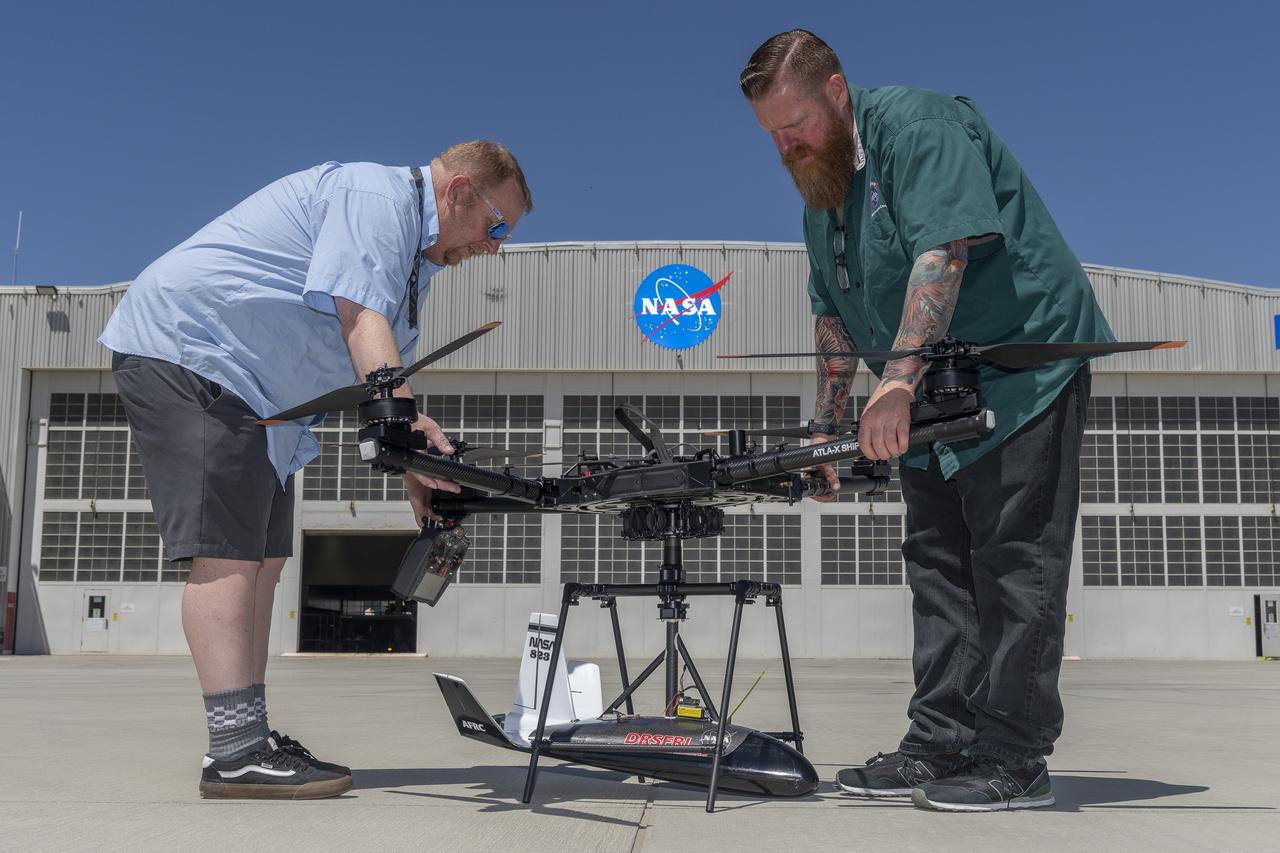 Robert “Red” Jensen and Justin Hall position an atmospheric probe, its host cradle, and the rotorcraft that will air launch the probe at NASA’s Armstrong Flight Research Center in Edwards, California. Jensen and Hall are designers, technicians, and pilots at the center’s Dale Reed Subscale Flight Research Laboratory.