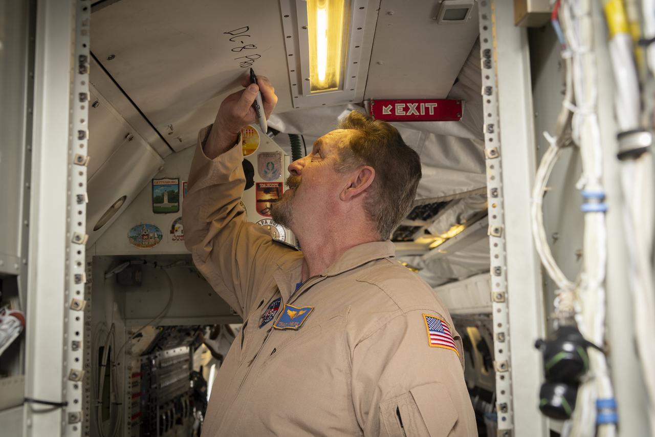 Aerospace engineer and research pilot Tracy Phelps signs the ceiling inside the DC-8 aircraft. Phelps piloted the aircraft’s final flight before it is retired from NASA’s Armstrong Flight Research Center Building 703 in Palmdale, California, to Idaho State University in Pocatello, Idaho. The DC-8 will provide real-world experience to train future aircraft technicians at the college’s Aircraft Maintenance Technology Program.