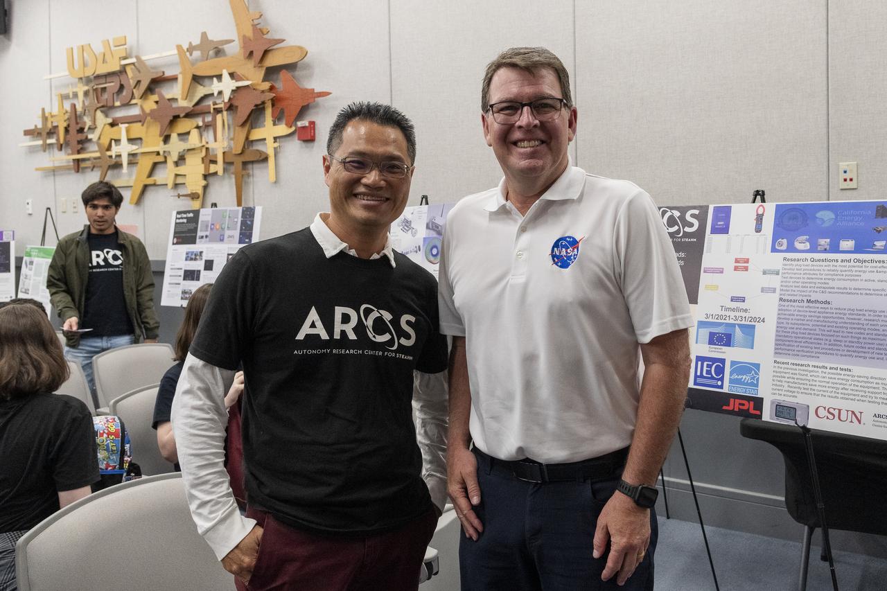 Nhut Ho, director of the NASA-sponsored Autonomy Research Center for science, technology, engineering, entrepreneurship, arts, humanities, and mathematics at California State University, Northridge, left, spoke to Brad Flick, center director at NASA’s Armstrong Flight Research Center in Edwards, California. The men were attending a student poster event, where students showcased their technologies and answered questions May 23 at the Air Force Test Pilot School auditorium on Edwards Air Force Base, California.