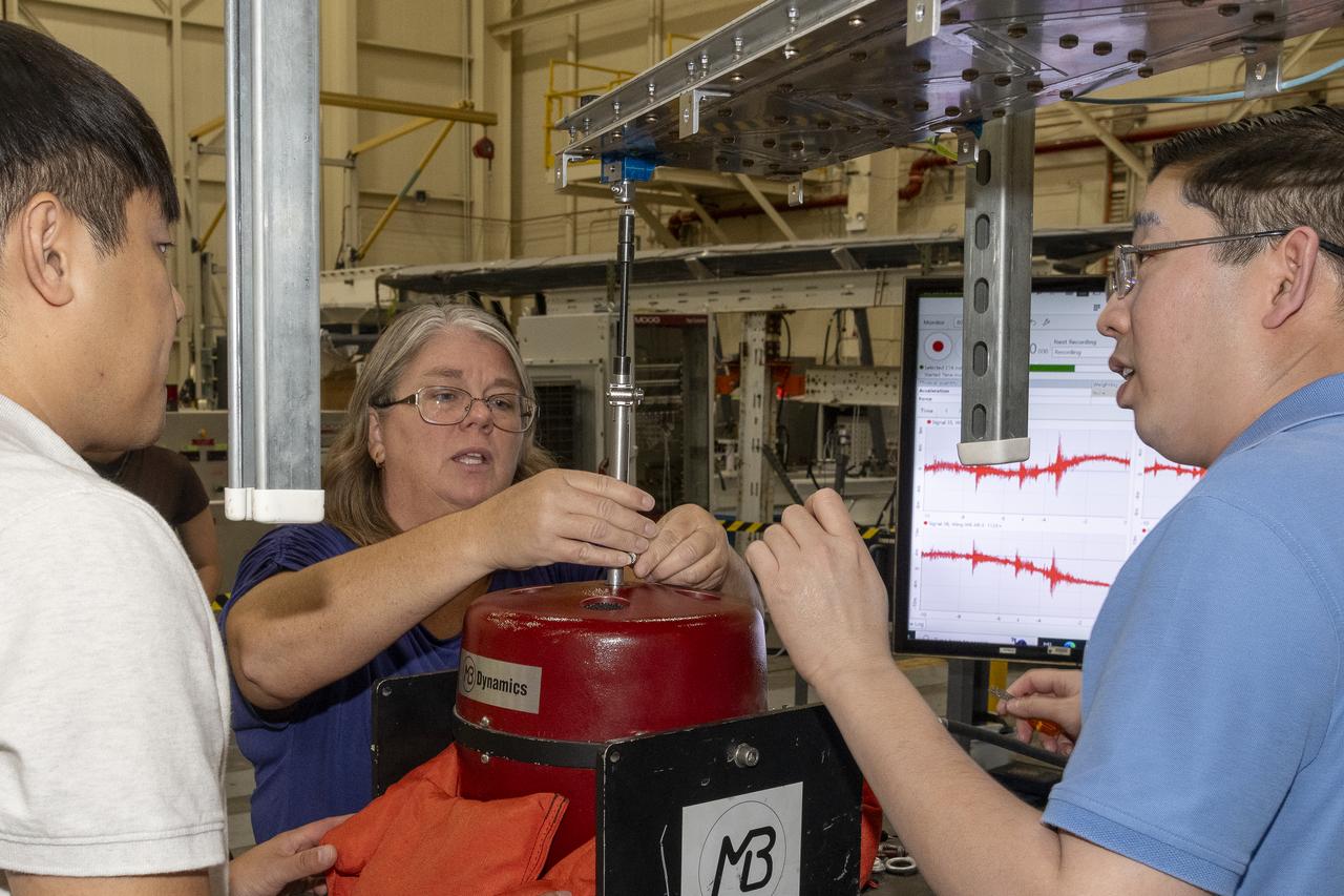 Researchers test a 10-foot Mock Truss-Braced Wing at NASA’s Armstrong Flight Research Center in Edwards, California. From left, ground vibration test director Ben Park, Natalie Spivey, and Samson Truong, prepare for a vibration test. The aircraft concept involves a wing braced on an aircraft using diagonal struts that also add lift and could result in significantly improved aerodynamics.