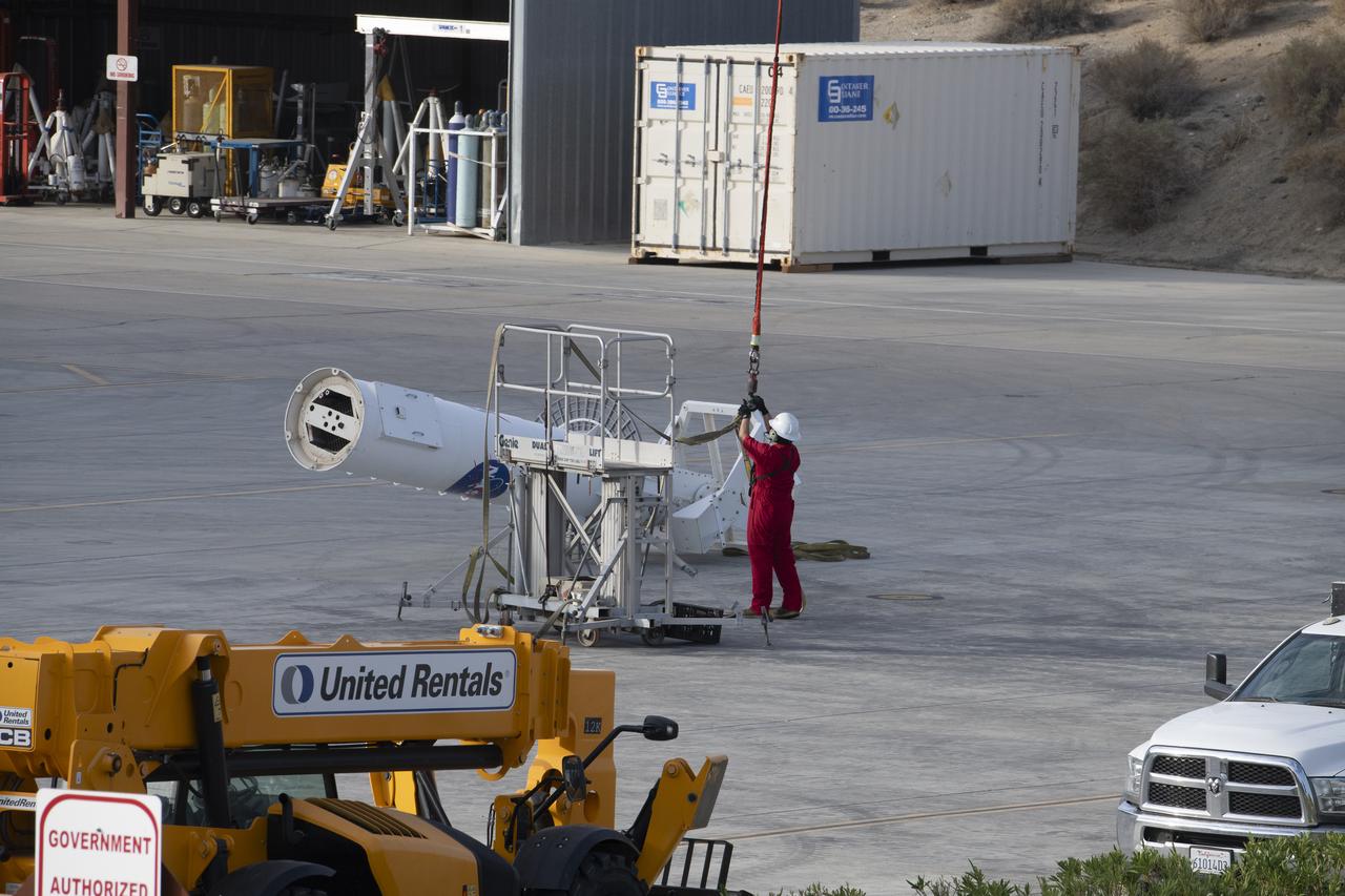 A pedestal carried by a helicopter is positioned for a gentle placement on the ground. The helicopter removed the pedestal from the rooftop of Building 4800 at NASA’s Armstrong Flight Research Center in Edwards, California, on Oct. 4, 2024. The pedestal was used since the 1950s to 2015 to house different telemetry dishes to collect data from research aircraft.