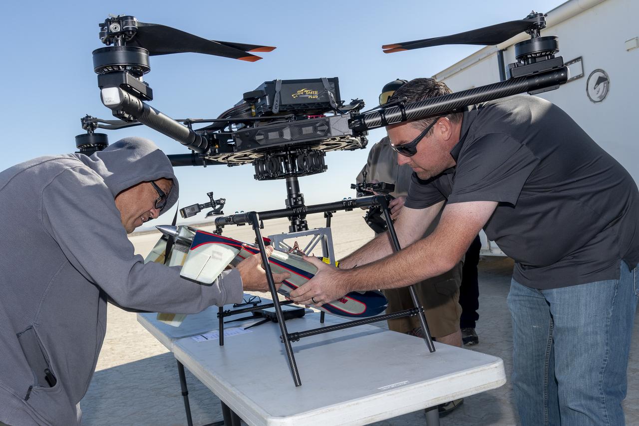Derek Abramson, left, chief engineer for the Dale Reed Subscale Flight Research Laboratory, and Justin Link, small unmanned aircraft systems pilot, prepare an atmospheric probe model for flight on Oct. 22, 2024. A quad rotor remotely piloted aircraft released the probe above Rogers Dry Lake, a flight area adjacent to NASA’s Armstrong Flight Research Center in Edwards, California. The probe was designed and built at the center.