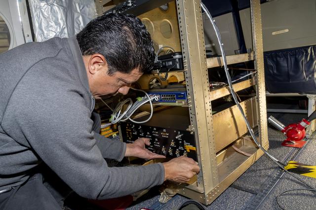 NASA image: Jose “Manny” Rodriguez adjusts Soxnav instrument onboard the G-IV