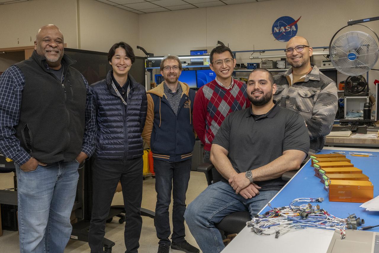 Allen Parker, Mark Hagiwara, Paul Bean, Patrick Chan, Jonathan Lopez (seated), and Frank Pena comprise the Fiber Optic Sensing System team at NASA’s Armstrong Flight Research Center, in Edwards, California. The systems on the table measure strain and temperature, critical safety data for hypersonic vehicles that travel five time the speed of sound.