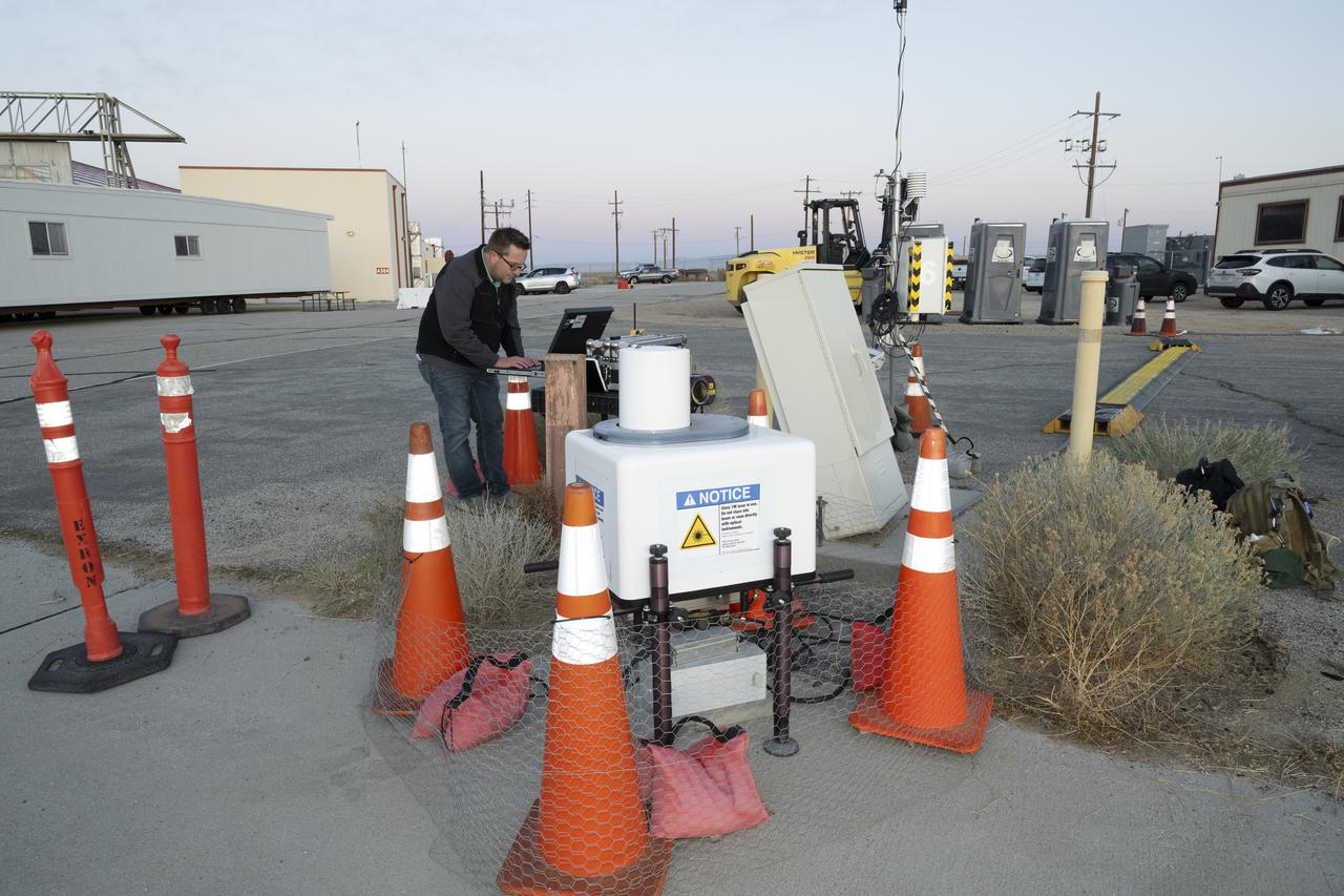 NASA aeronautical meteorologist Luke Bard adjusts one of several wind lidar (light detection and ranging) sensors near NASA’s Armstrong Flight Research Center in Edwards, California, on March 12, 2025, in preparation to collect data from Joby Aviation’s experimental air taxi aircraft. NASA is collecting information during this study to help advance weather-tolerant air taxi operations for the entire industry