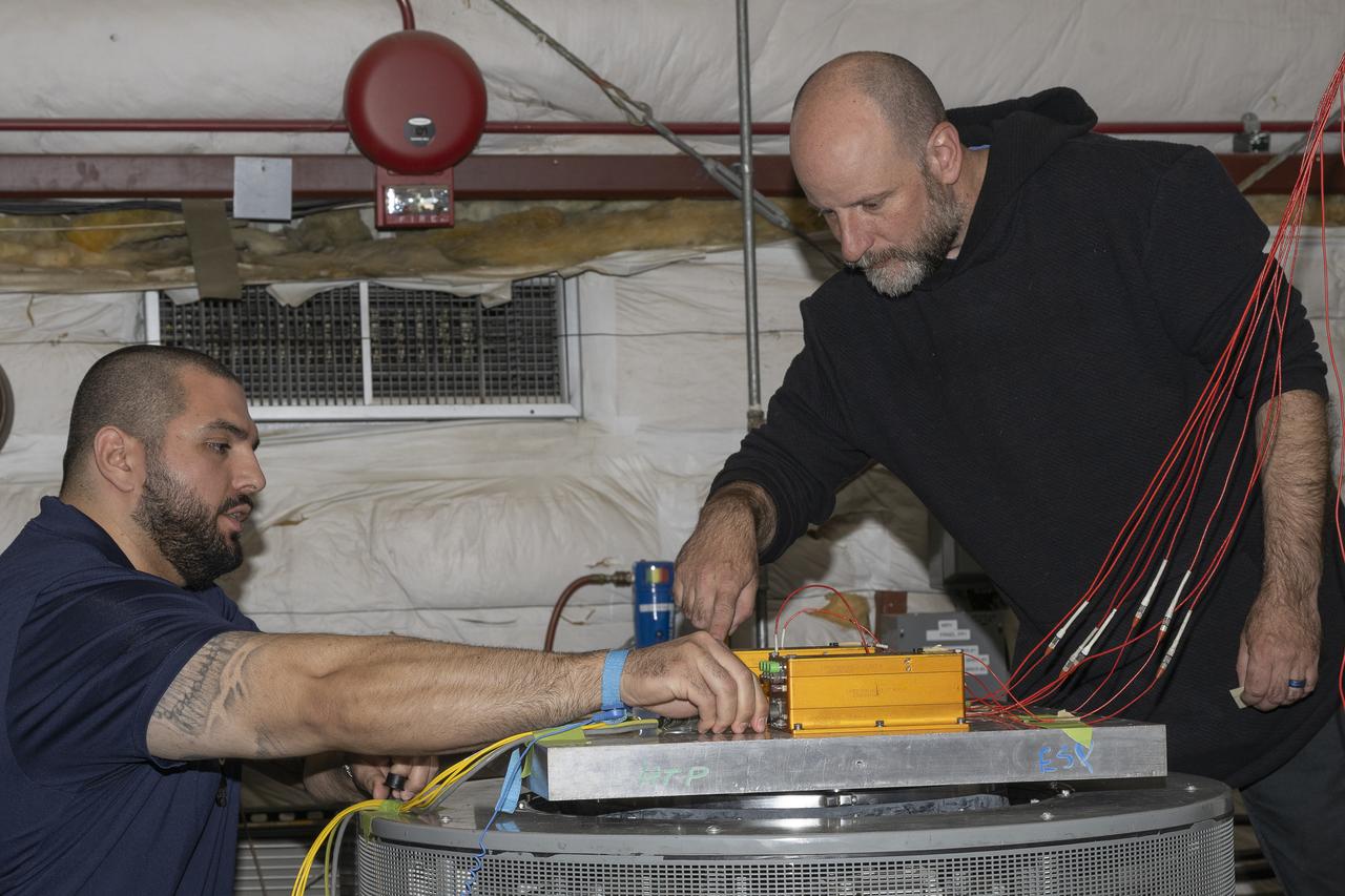 Jonathan Lopez and Nathan Rick prepare the hypersonic Fiber Optic Sensing System for vibration tests in the Environmental Laboratory at NASA’s Armstrong Flight Research Center in Edwards, California. Testing on a machine called a shaker proved that the system could withstand the severe vibration it will endure in hypersonic flight, or travel at five times the speed of sound.