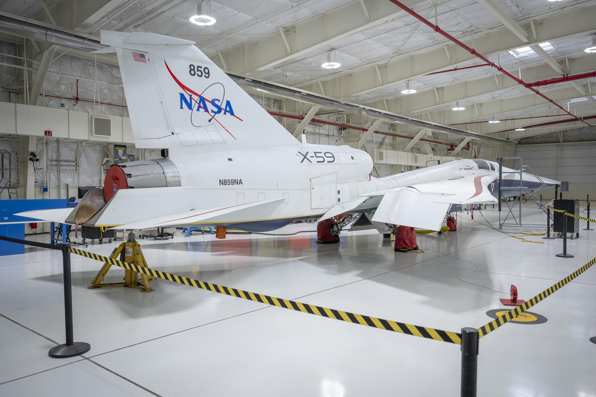 NASA’s X-59 quiet supersonic research aircraft sits inside Hangar 4826 at NASA’s Armstrong Flight Research Center in Edwards, California, on Nov. 18, 2025. Following its first flight on Oct. 25, 2025, in support of NASA’s Quesst mission, the aircraft entered scheduled maintenance as part of its transition into flight operations. Quesst aims to demonstrate quiet supersonic flight and reduce the disruptive sonic boom to a quieter sonic thump.