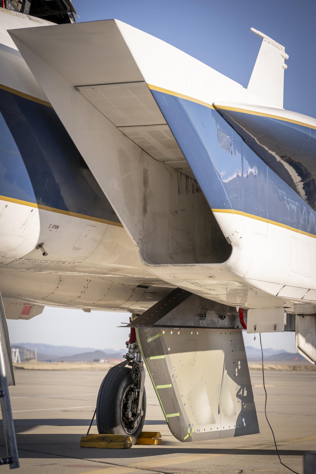NASA’s Cross Flow Attenuated Natural Laminar Flow test article is mounted beneath the agency’s F-15 research aircraft ahead of the design’s high-speed taxi test on Tuesday, Jan. 12, 2026, at NASA’s Armstrong Flight Research Center in Edwards, California. The 3-foot-tall scale model is designed to increase a phenomenon known as laminar flow and reduce drag, improving efficiency in large, swept wings like those found on most commercial aircraft.