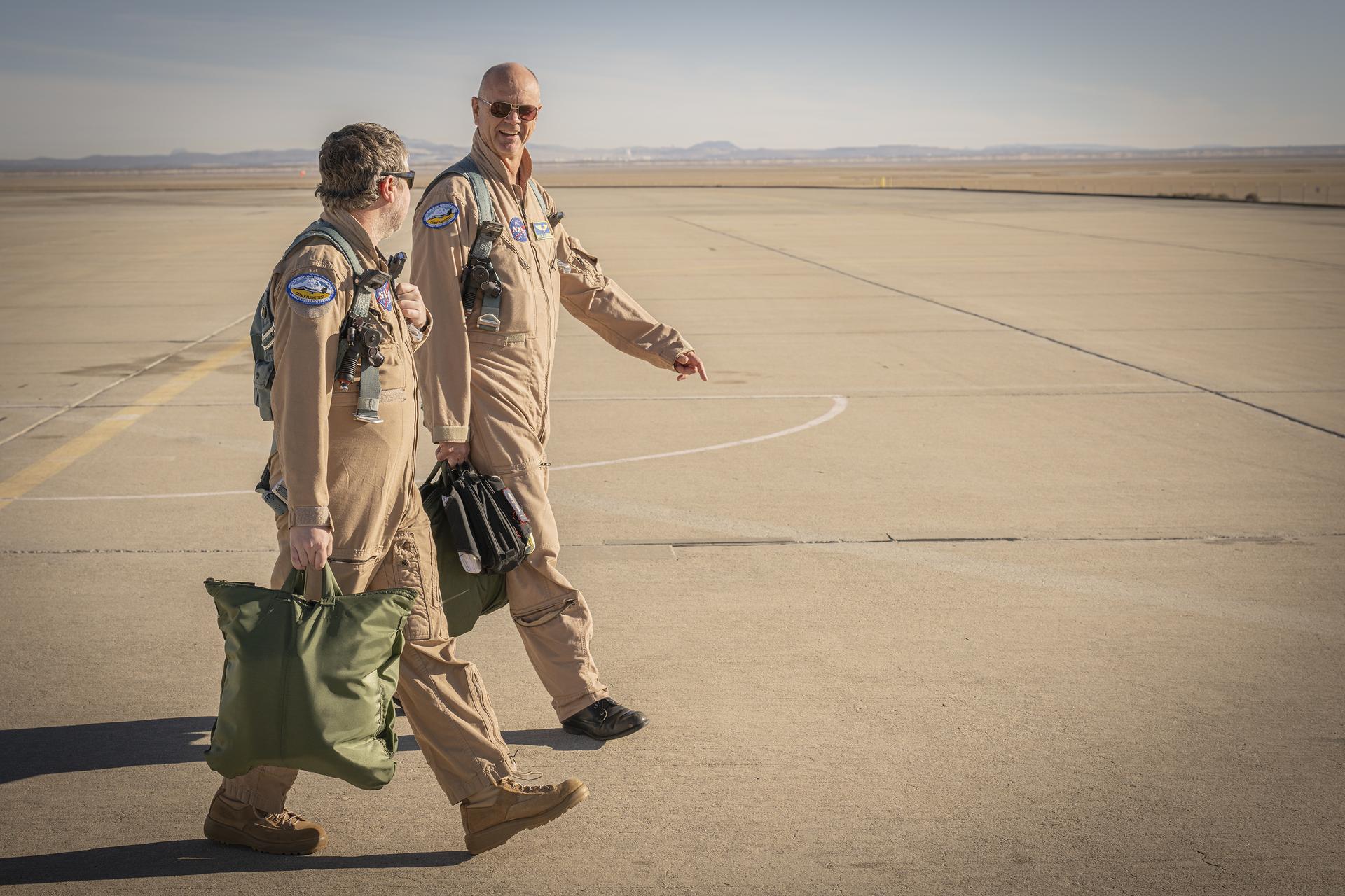 NASA flight test engineer A.J. Jaffe and pilot Nils Larson walk on the ramp before a flight Tuesday, Jan. 13, 2026, at NASA’s Armstrong Flight Research Center in Edwards, California. The two support the agency’s Crossflow Attenuated Natural Laminar Flow (CATNLF) project, which aims to lower fuel costs for future commercial aircraft by testing a scale-model wing designed to improve laminar flow.