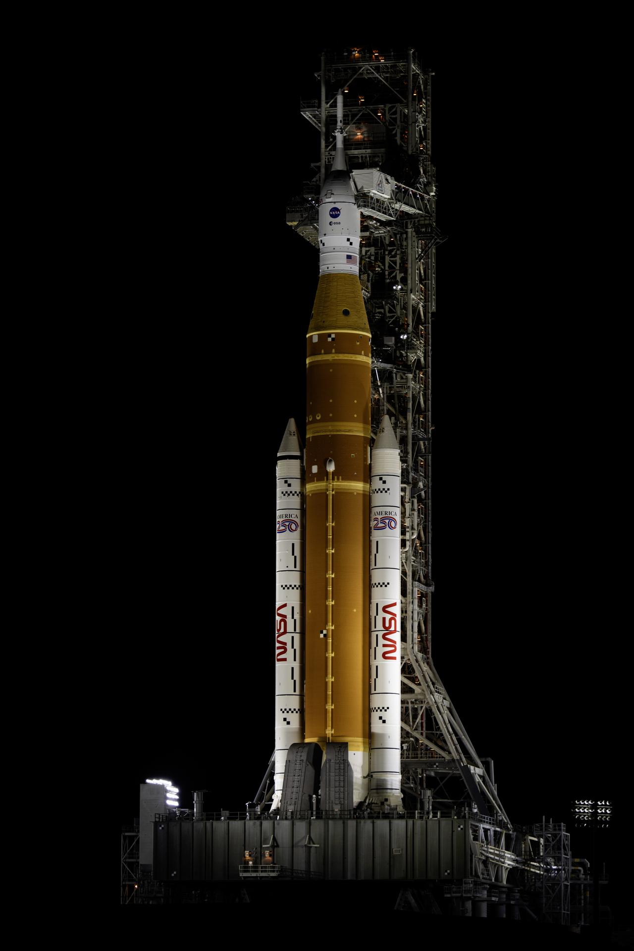 Spotlights illuminate NASA’s Artemis II SLS (Space Launch System) rocket with the Orion spacecraft atop a mobile launcher at Launch Complex 39B at NASA’s Kennedy Space Center in Florida on Thursday, Jan. 29, 2026. The Artemis II test flight will take Commander Reid Wiseman, Pilot Victor Glover, and Mission Specialist Christina Koch from NASA, and Mission Specialist Jeremy Hansen from the CSA (Canadian Space Agency), around the Moon and back to Earth.