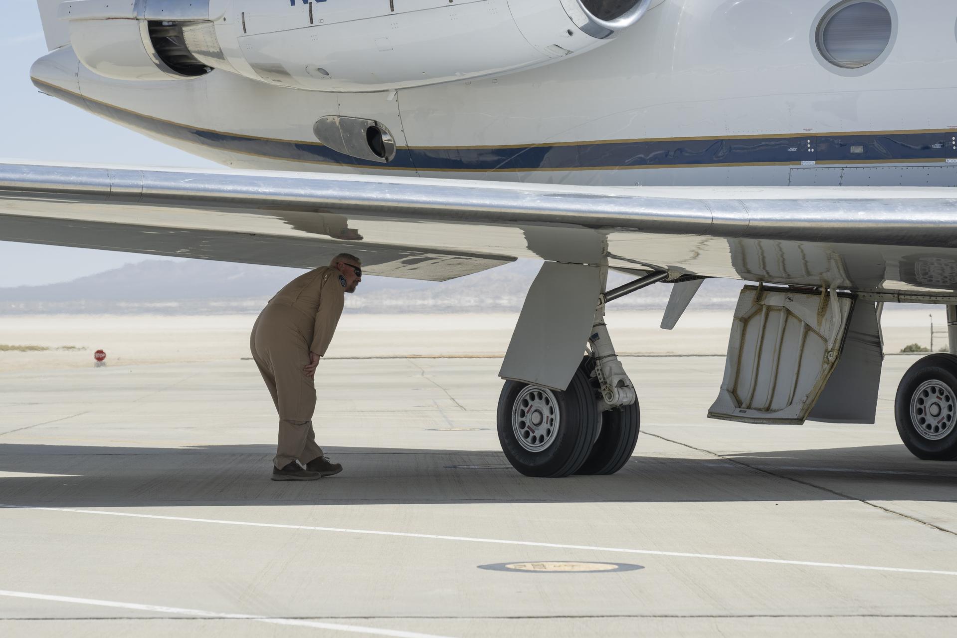 NASA pilot Tracy Phelps inspects the Gulfstream G-III aircraft on Friday, March 27, 2026, at NASA’s Armstrong Flight Research Center in Edwards, California. The G-III will join other NASA aircraft to capture imagery of the Orion spacecraft’s heat shield during Artemis II reentry. The mission is part of NASA’s Scientifically Calibrated In-Flight Imagery (SCIFLI) project, based at NASA’s Langley Research Center in Hampton, Virginia.